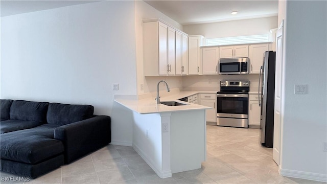 kitchen featuring sink, white cabinetry, light tile patterned flooring, kitchen peninsula, and stainless steel appliances