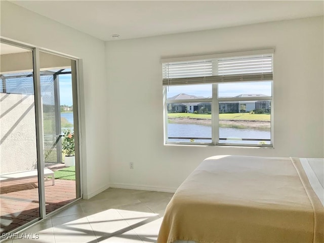 bedroom with access to exterior, light tile patterned flooring, and a water view