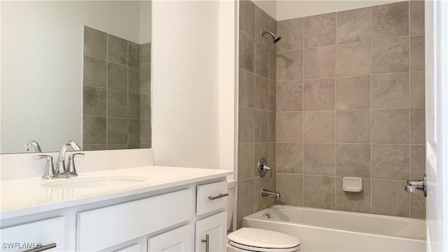 full bathroom featuring vanity, tiled shower / bath combo, and toilet