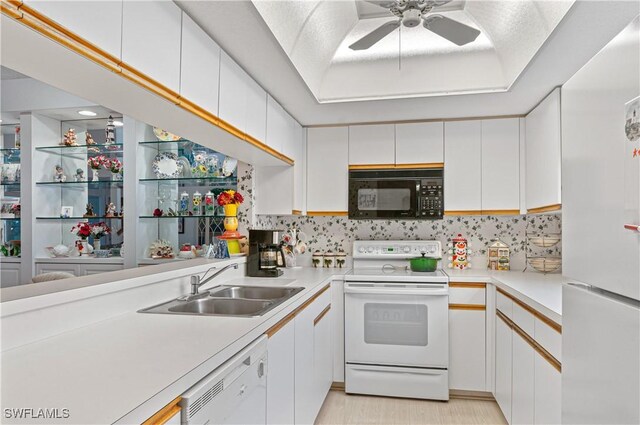 kitchen with white appliances, white cabinetry, and sink