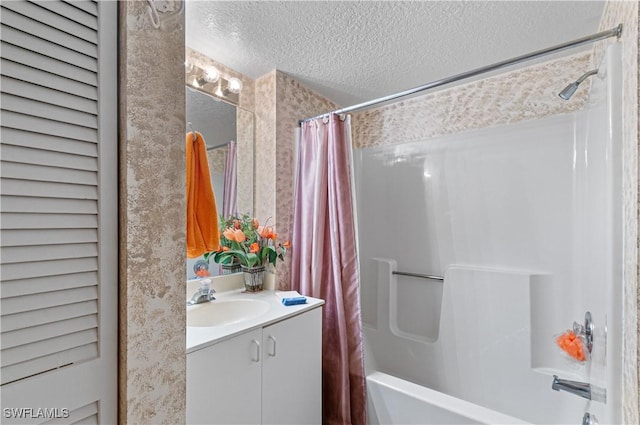 bathroom with shower / bath combo, a textured ceiling, and vanity