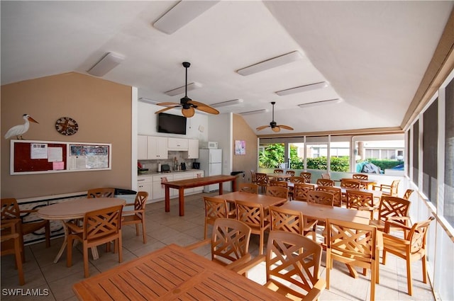 tiled dining room with ceiling fan and vaulted ceiling