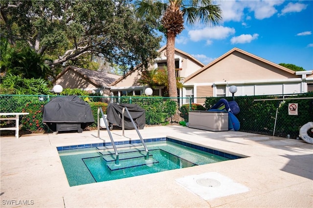 view of pool with area for grilling, a hot tub, and a patio area