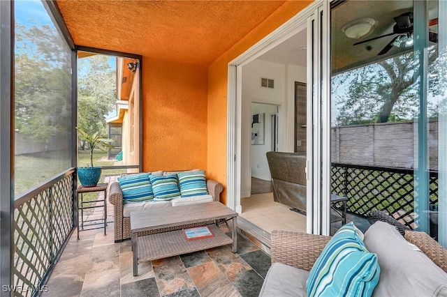 sunroom featuring ceiling fan