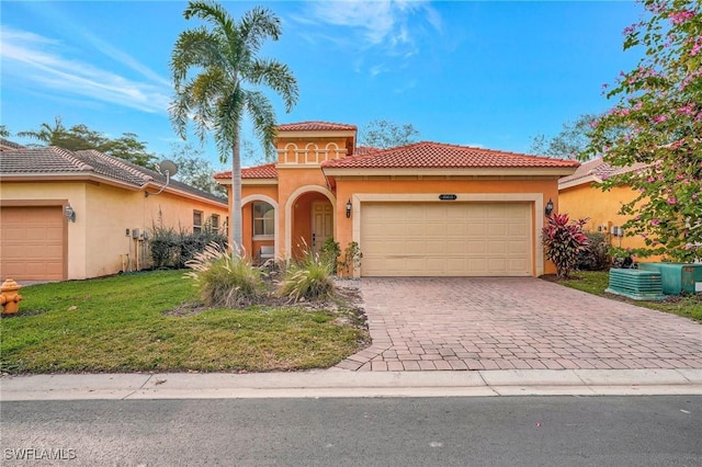 mediterranean / spanish house featuring a front yard and a garage