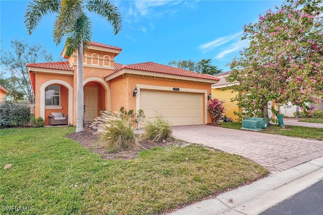 mediterranean / spanish home featuring a front lawn and a garage