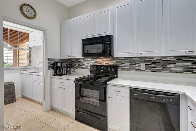 kitchen with black appliances, white cabinets, sink, and light tile patterned floors