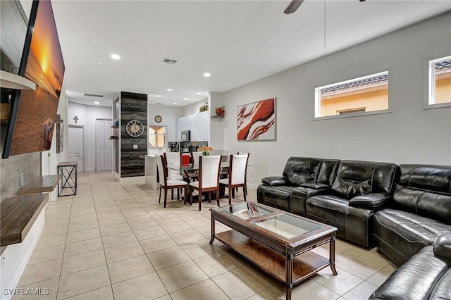 living room featuring ceiling fan, light tile patterned floors, and a healthy amount of sunlight