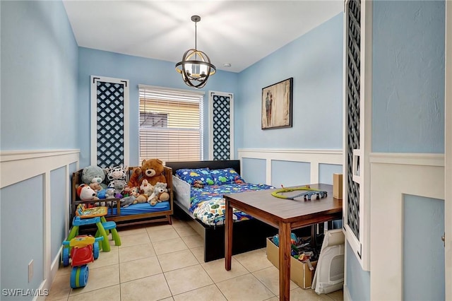 bedroom with light tile patterned floors and an inviting chandelier