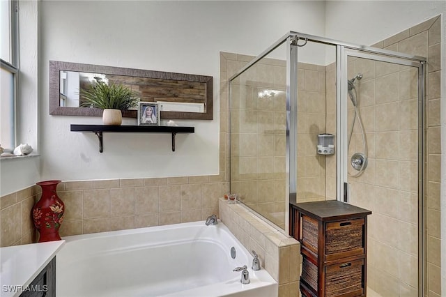 bathroom with vanity and shower with separate bathtub