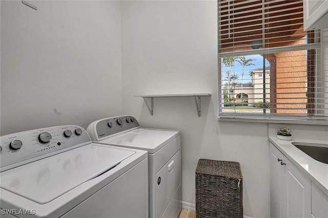 laundry room featuring cabinets, sink, and washing machine and dryer