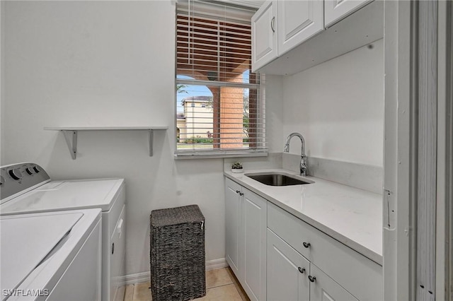 clothes washing area with light tile patterned floors, cabinets, washer and dryer, and sink