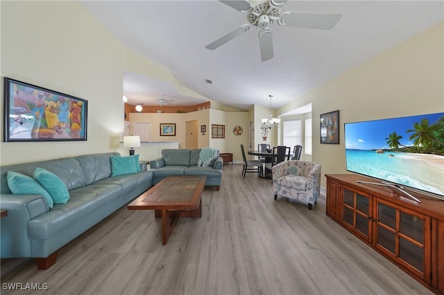 living room with ceiling fan with notable chandelier, light hardwood / wood-style floors, and lofted ceiling