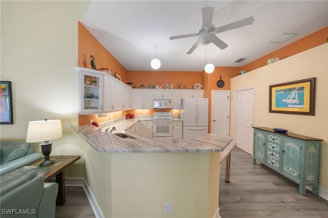 kitchen featuring white cabinetry, light hardwood / wood-style flooring, kitchen peninsula, pendant lighting, and white appliances