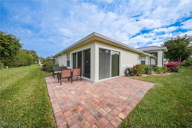 back of property featuring a lawn and a patio