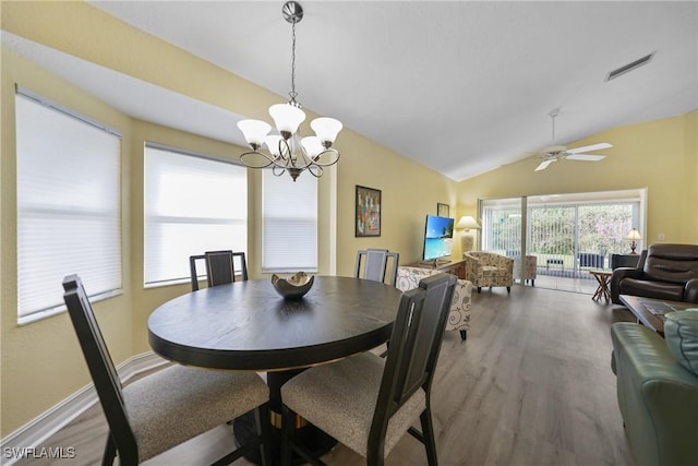 dining area with hardwood / wood-style floors, ceiling fan with notable chandelier, and lofted ceiling