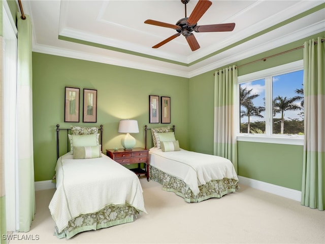 carpeted bedroom featuring ornamental molding, ceiling fan, and a tray ceiling