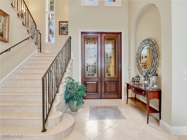 tiled entrance foyer with a high ceiling