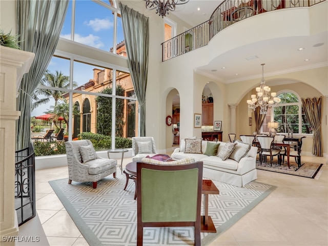 living room featuring a notable chandelier, light tile patterned floors, ornamental molding, and a towering ceiling