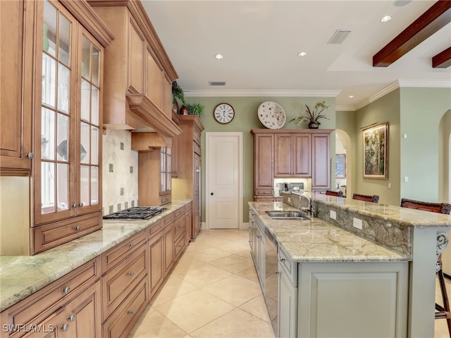 kitchen with sink, light stone counters, a kitchen breakfast bar, and a large island