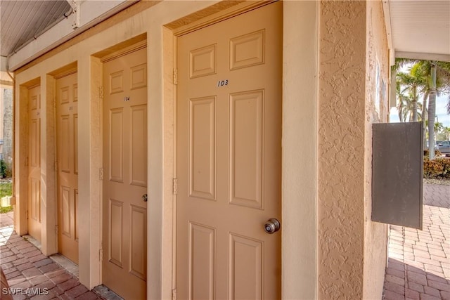 1118 SW 48th Ter Unit 104, Cape Coral, FL 33914 - doorway to property with stucco siding
