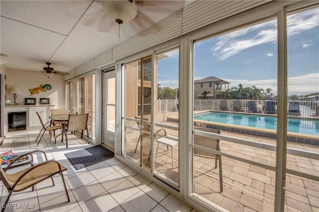 sunroom / solarium featuring ceiling fan