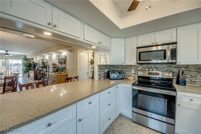 kitchen featuring ceiling fan, white cabinets, tasteful backsplash, light stone countertops, and stainless steel appliances