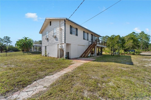 view of side of home with a deck and a lawn