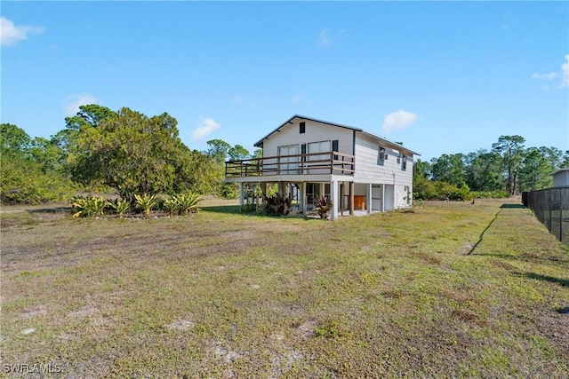 rear view of property with a lawn and a wooden deck