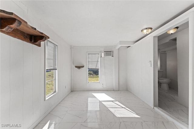 empty room with an AC wall unit and wood walls