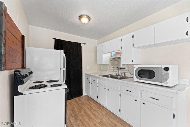 kitchen featuring white cabinetry, sink, light hardwood / wood-style floors, a textured ceiling, and white appliances