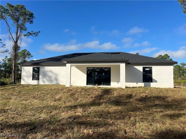 rear view of property featuring a lawn