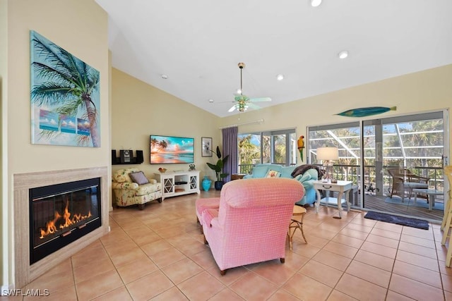 living room with ceiling fan, light tile patterned floors, and lofted ceiling