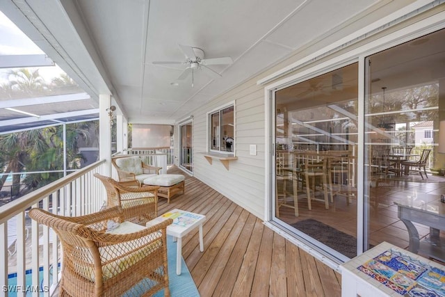 wooden deck with glass enclosure and ceiling fan