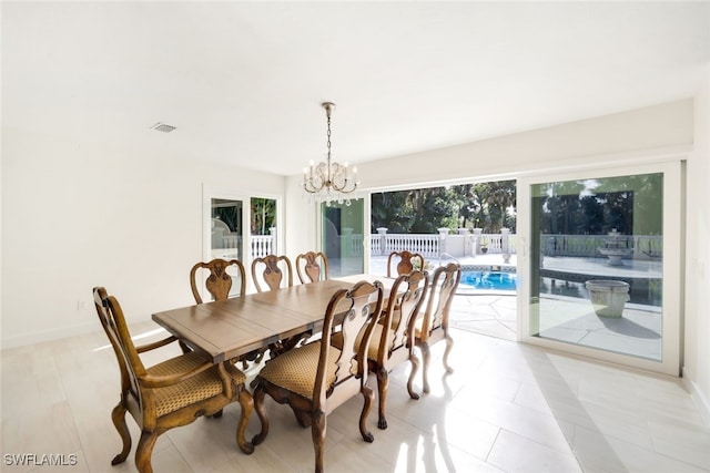 dining room with light tile patterned flooring and a chandelier