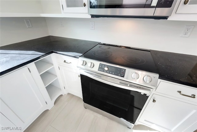 kitchen featuring white cabinets and stainless steel range with electric cooktop