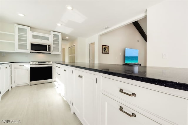 kitchen featuring white cabinetry, dark stone counters, and appliances with stainless steel finishes