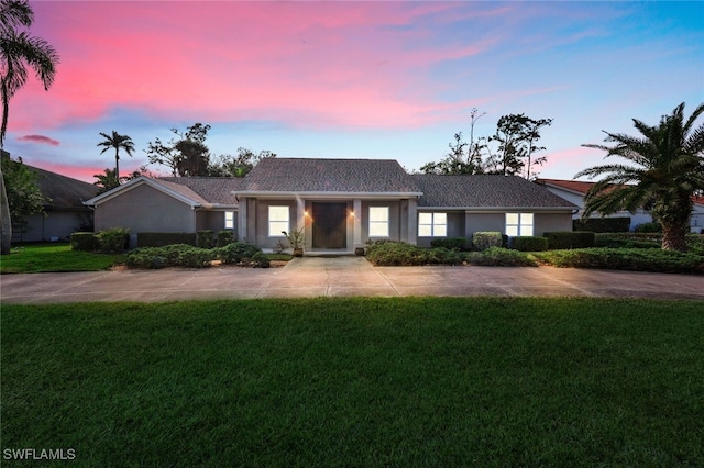 single story home featuring a lawn