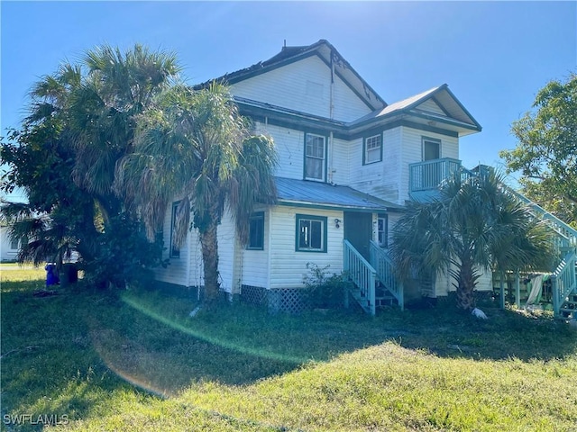 view of front of property featuring a balcony and a front yard