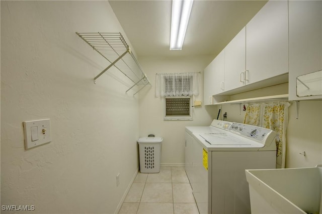 laundry room featuring cabinets, sink, light tile patterned floors, and washer and dryer