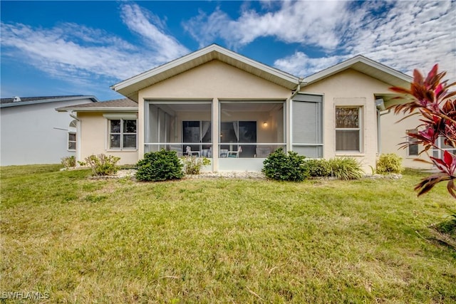 rear view of property with a lawn and a sunroom