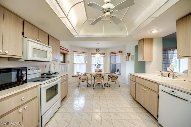 kitchen with light brown cabinets, white appliances, sink, ceiling fan, and decorative light fixtures