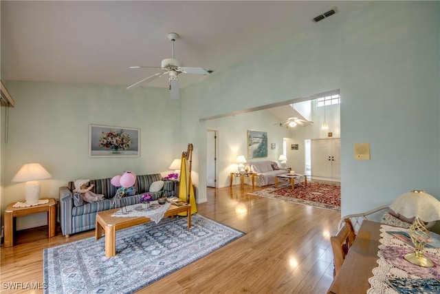 living room featuring ceiling fan, light hardwood / wood-style floors, and lofted ceiling