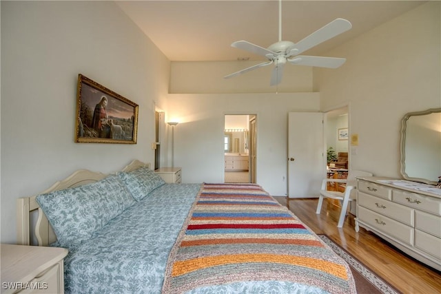 bedroom with connected bathroom, ceiling fan, high vaulted ceiling, and light wood-type flooring