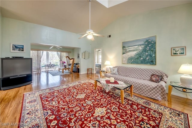 living room featuring hardwood / wood-style flooring, vaulted ceiling, and ceiling fan