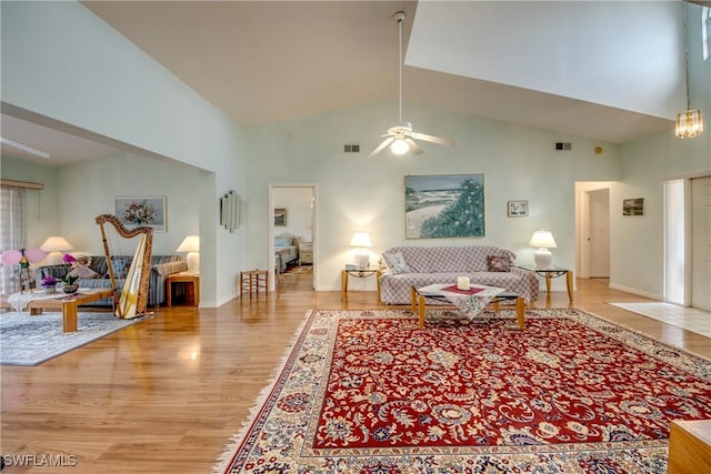 living room with light hardwood / wood-style flooring, high vaulted ceiling, and ceiling fan