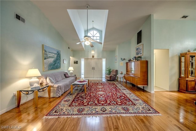 living room featuring wood-type flooring, high vaulted ceiling, and ceiling fan