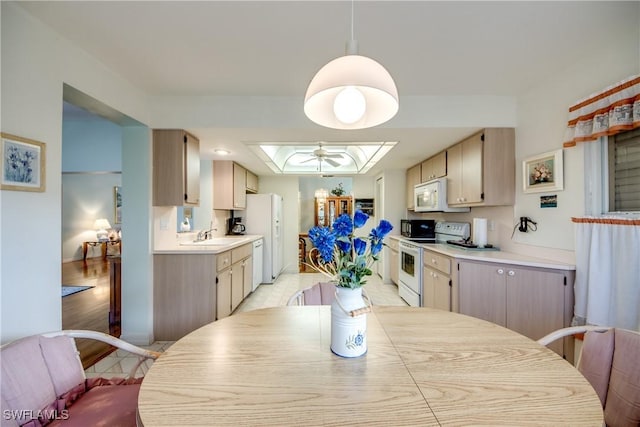 dining room featuring a skylight, ceiling fan, and sink