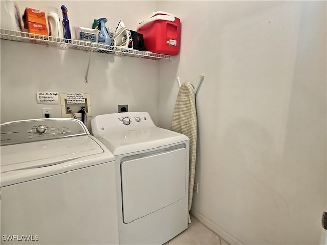 clothes washing area featuring washer and dryer and light tile patterned floors