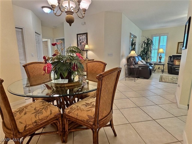 dining room with light tile patterned floors and a notable chandelier